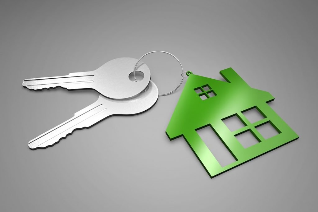 An image of two silver keys attached to a green house keyring