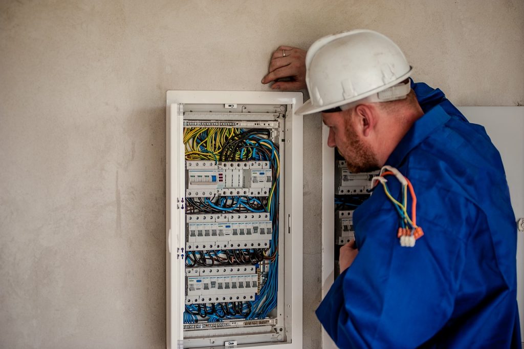 Picture of a qualified electrician working precisely with an electricity board