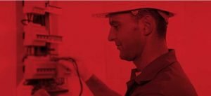 An image of an electrician working on a wiring board