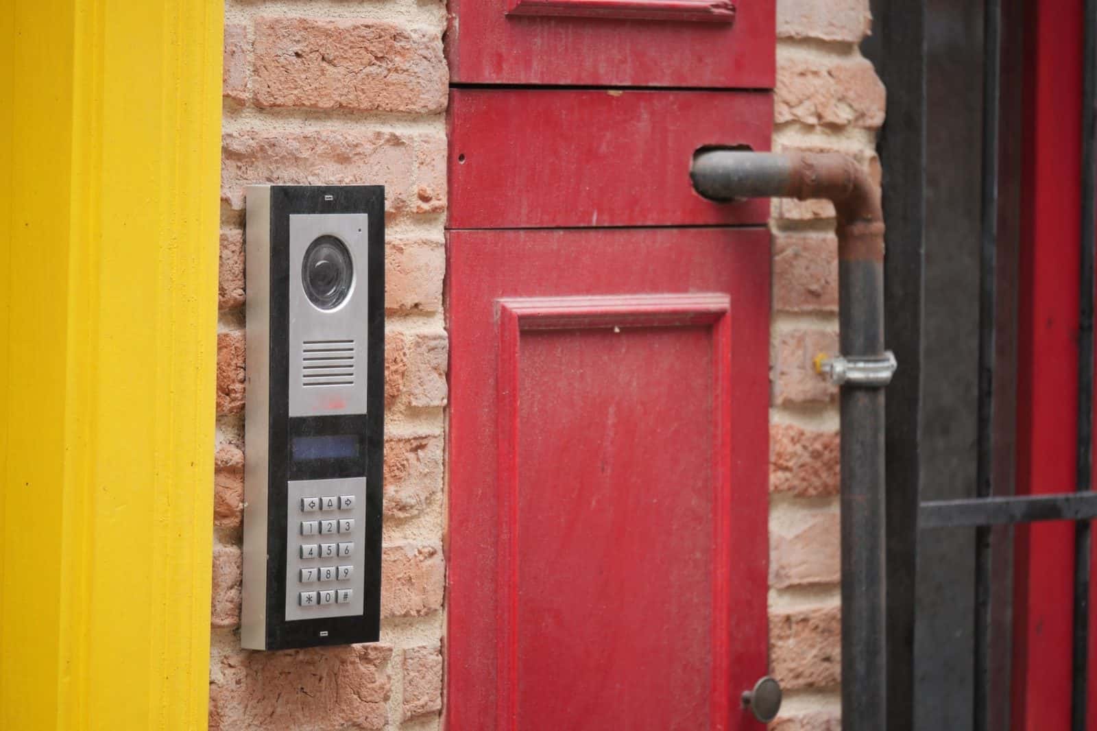 Communal video intercom and keypad beside the entrance of a London building